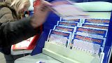  A customer picks up a Lotto ticket in a Paris shop in 2006.