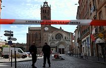 Security personnel gather at the entrance of Saint Etienne Cathedral in Toulouse.