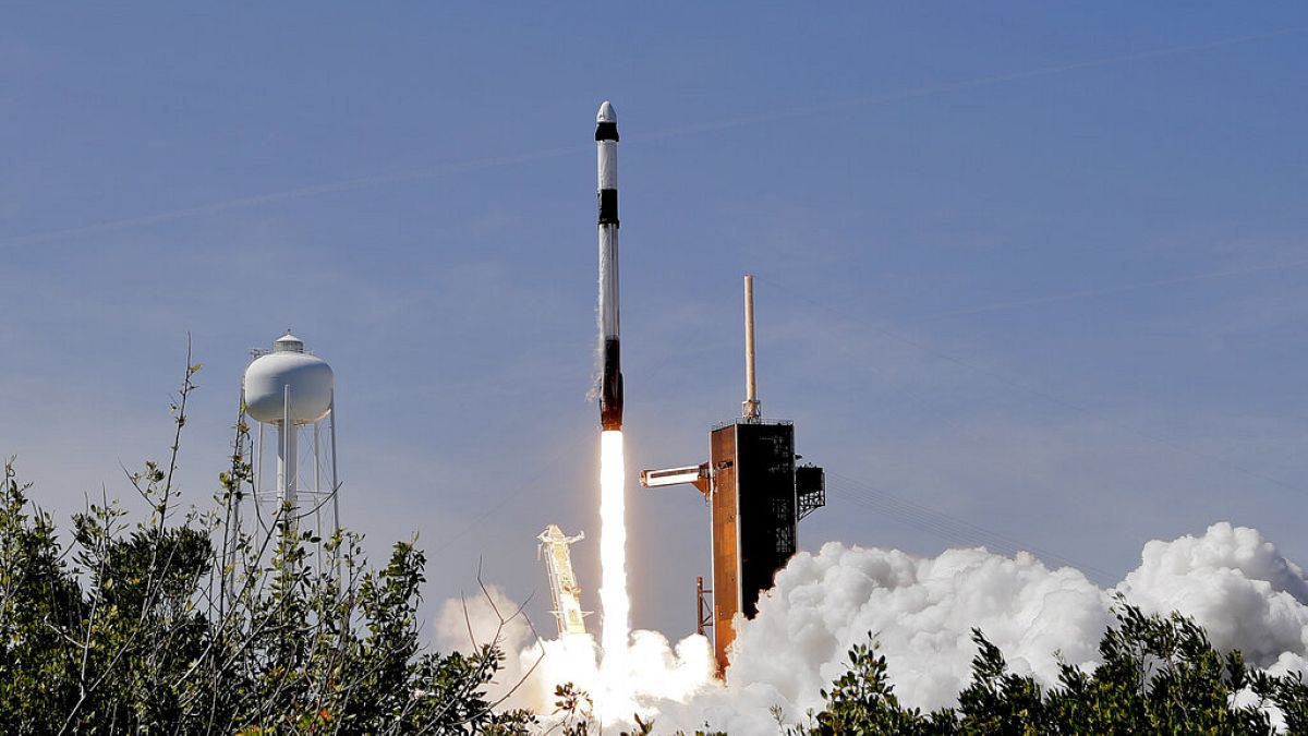 A SpaceX Falcon 9 rocket with the Crew Dragon capsule attached, lifts off with the first private crew from Launch Complex 39