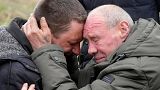 Relatives cry at the mass grave of civilians killed during Russian occupation in Bucha, on the outskirts of Kyiv, Ukraine, Friday, April 8, 2022