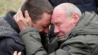 Relatives cry at the mass grave of civilians killed during Russian occupation in Bucha, on the outskirts of Kyiv, Ukraine, Friday, April 8, 2022