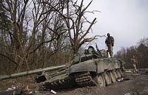 Un soldat ukrainien se tient au sommet d'un char russe détruit dans la région de Tchernihiv, en Ukraine, le vendredi 8 avril 2022. 