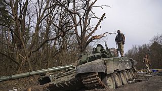 Un soldat ukrainien se tient au sommet d'un char russe détruit dans la région de Tchernihiv, en Ukraine, le vendredi 8 avril 2022.