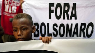 Un enfant tient une banderole sur laquelle on peut lire "Bolsonaro dehors" lors d'une manifestation contre la politique économique du président brésilien