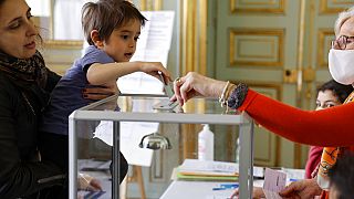 Mutter mit Sohn bei der Stimmabgabe in Frankreich