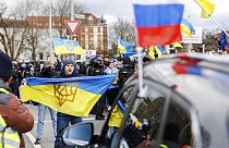 Διαδηλωτής με ουκρανική σημαία μπροστά από αυτοκίνητο μιας φιλορωσικής αυτοκινητοπομπής στο Friedrichswall στο Ανόβερο της Γερμανίας την Κυριακή, 10 Απριλί