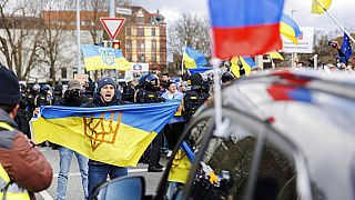 Διαδηλωτής με ουκρανική σημαία μπροστά από αυτοκίνητο μιας φιλορωσικής αυτοκινητοπομπής στο Friedrichswall στο Ανόβερο της Γερμανίας την Κυριακή, 10 Απριλί