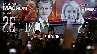 Uno schermo mostra il presidente francese Emmanuel Macron, candidato centrista per la rielezione e la sua sfidante di estrema destra Marine Le Pen