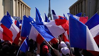 تکان دادن پرچم‌های فرانسه در پاریس در یکی از کارزارهای انتخاباتی