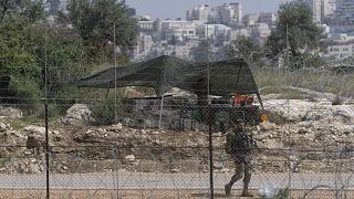 Izraeli katona őrködik a ciszjordániai határkerítésnél