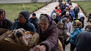 People receive food from a church in the town of Borodyanka, about 40 miles northwest of Kyiv, Ukraine, on Sunday, April 10, 2022