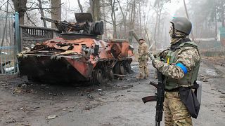 Des soldats ukrainiens devant un véhicule militaire détruit, à Irpin, près de Kyiv, en Ukraine,  1er avril 2022.
