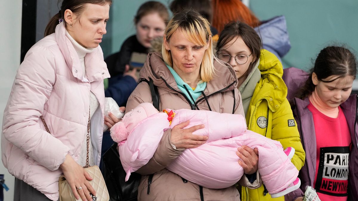 Женщины-беженцы с детьми на центральном железнодорожном вокзале в Варшаве, Польша.