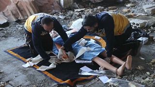 Zwei syrische Rettungskräfte zeigen die Versorgung von Kriegsopfern