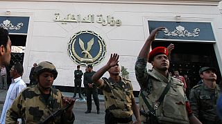 جنود مصريون يقفون أمام مبنى وزارة الداخلية بعد إضرام النار فيه من قبل ضباط شرطة خلال مظاهرة للمطالبة بتحسين ظروف العمل في القاهرة، مصر، الثلاثاء 22 مارس 2011