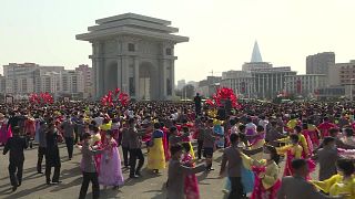 Students and youth wearing face masks dance in Pyongyang to commemorate the 10th anniversary of North Korean leader Kim Jong Un in power.