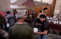 Syrians queue to receive free Iftar meals being distributed by a local charity in the capital of Damascus.