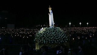 The statue of Our Lady of Fatima is carried past worshippers holding candles in a procession at the Catholic shrine in Fatima, Portugal, Wednesday, May 12, 2021.