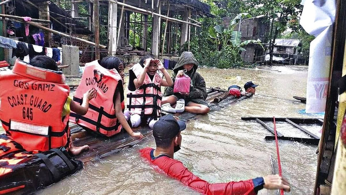 Des résidents sont évacués par des sauveteurs dans un village inondé à Panitan, sur l'île de Panay, (Philippines) le mardi 12 avril 2022.