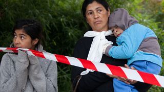 A Roma family waiting at a barrier.
