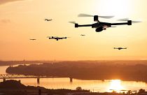 Image shows drones at sunset. Researchers in Spain have conducted a mass drone flight test to trial a new traffic management system for UAVs