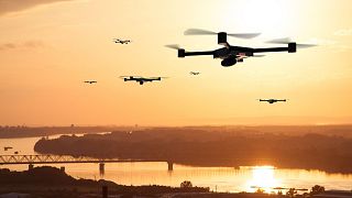 Image shows drones at sunset. Researchers in Spain have conducted a mass drone flight test to trial a new traffic management system for UAVs