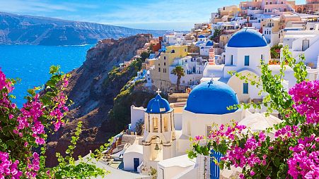 Oia town, Santorini island, with its traditional white houses and blue-domed churches.