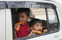 Unos niños comen un helado sentados en un coche en Prayagraj, en el norteño estado indio de Uttar Pradesh, 13/4/2022.