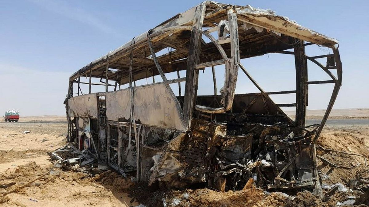 The charred remains of the bus pictured on an Egyptian road south of Aswan.