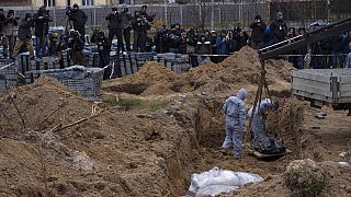 Buça'da öldürülen bir sivilin cesedi mezarlıktan çıkarılıyor, 13 Nisan 2022