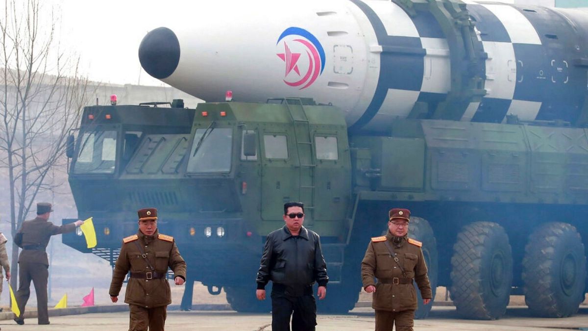Kim Jong Un, center, walks around what it says a Hwasong-17 intercontinental ballistic missile