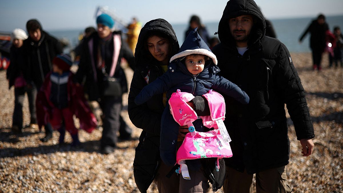Migrants walk up the shore after being rescued by the RNLI (Royal National Lifeboat Institution) while crossing the English Channel, in Dungeness, Britain, March 15, 2022.