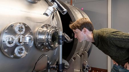 Image shows CEO and Co-founder of First Light Fusion, Dr. Nick Hawker inspecting machinery at his factory that aim to cheaply create green energy via nuclear fusion.