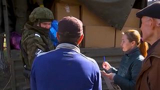 جندي روسي يوزع المساعدات على السكان في مدينة خاركيف