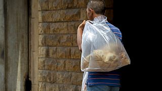 رجل يحمل خبزا خارج مخبز في بيروت، لبنان، السبت 27 يونيو 2020