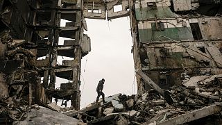 A resident looks for belongings in an apartment building destroyed during fighting between Ukrainian and Russian forces in Borodianka, Ukraine, Tuesday, April 5, 2022.