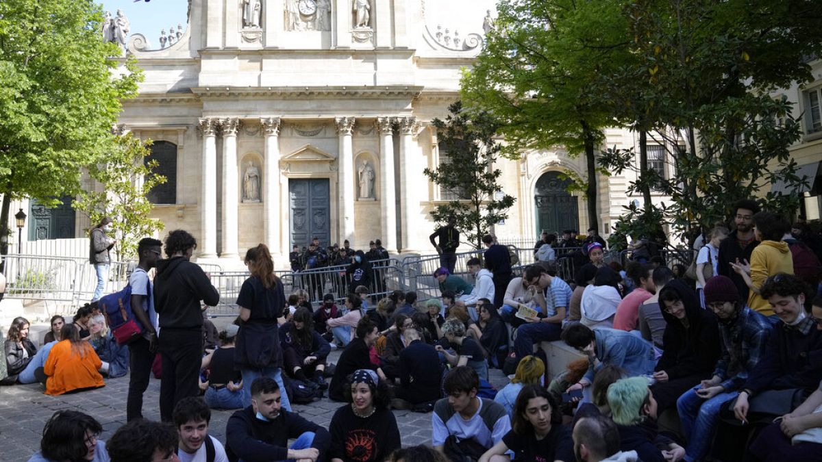 Students sit outside La Sorbonne university, Thursday, April 14, 2022 in Paris.