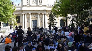 Students sit outside La Sorbonne university, Thursday, April 14, 2022 in Paris.