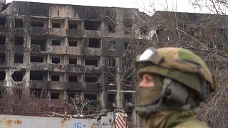 جندي امام مبنى مدمر في ماريوبول