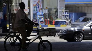 صورة لشخص يقود دراجة أمام محطة لبيع البنزين في القاهرة