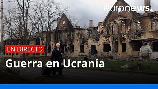 Una mujer camina entre las ruinas de Mariupol