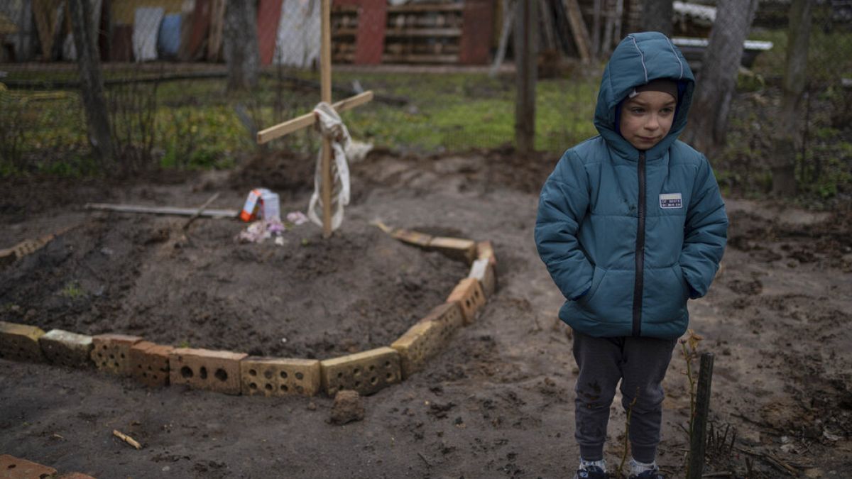 Vlad, 6, steht neben dem Grab seiner Mutter in einer Kiewer Vorstadt. Die Familie hielt sich einen Monat in einem Bunker vor den russischen Truppen versteckt. 4. April 2022