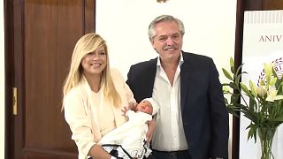 Alberto Fernández con su hijo recien nacido y su compañera, a la salida de la clínica