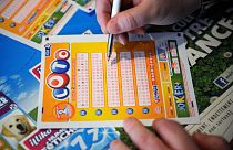 A French gambler fills in a lottery ticket of Super Loto.