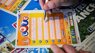 A French gambler fills in a lottery ticket of Super Loto.