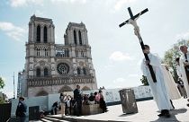 Un prelado lleva la santa cruz en la ceremonia del Vía Crucis como parte de la celebración de la Santa Pascua, frente a la Catedral de Notre Dame, en París, 15/4/2022