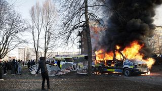 Police vans are on fire as counter-protesters react during a counter-protest in the park Sveaparken in Orebro, south-centre Sweden on April 15, 2022.