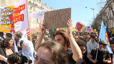 Demonstrator holding up a sign "The youth says to hell with the National Front".