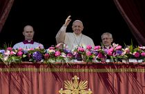 Pope Francis, centre, waves to the crowd after the traditional 'Urbi et Orbi' blessing after Easter Sunday mass in St. Peter's Square at the Vatican, Sunday, April 17, 2022.