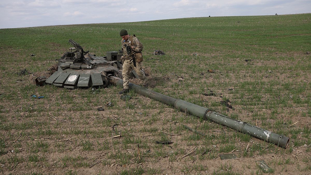 An Ukrainian serviceman walks past destroyed Russian tank near Gusarovka village, in Kharkiv oblast, eastern Ukraine.